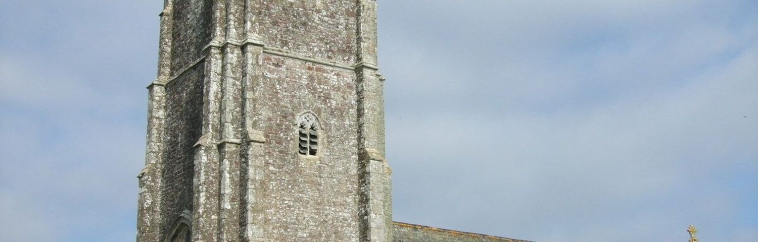 A historic church with a tall tower and a graveyard in front.