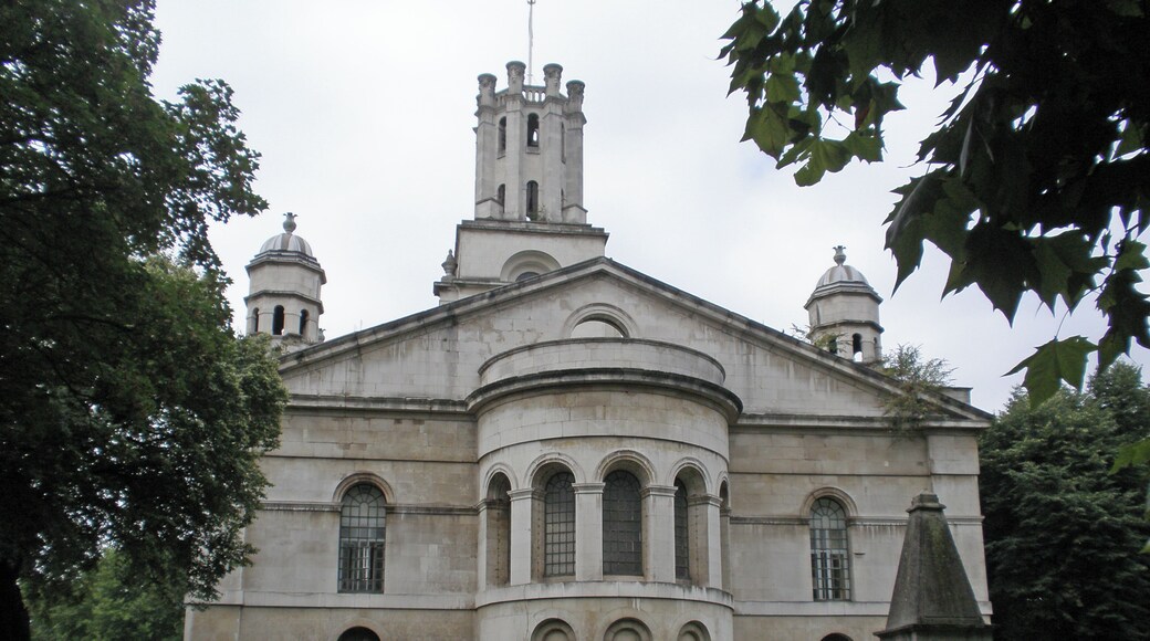 St George-in-the-East is an Anglican Church dedicated to Saint George and one of six Hawksmoor churches in London, England. It was built from 1714 to 1729, with funding from the 1711 Act of Parliament. The name of the church was also the parish for the surrounding area, until subsumed into Metropolitan Borough of Stepney and abolished in 1927. The church was hit by a bomb during the Second World War Blitz on London's docklands in May 1941. The original interior was destroyed by the fire, but the walls and distinctive "pepper-pot" towers stayed up. In 1964 a modern church interior was constructed inside the existing walls, and a new flat built under each corner tower. Hawksmoor, who worked with Wren and Vanburgh, has been 'rediscovered' in recent years. His style is innovative and eclectic. Some have portrayed his churches as centres of gloom and mystery, full of occult and morbid energies and pagan symbols, linked to ancient lay lines and to murders in Whitechapel and on the notorious Ratcliffe Highway (which now links the City and Canary Wharf).