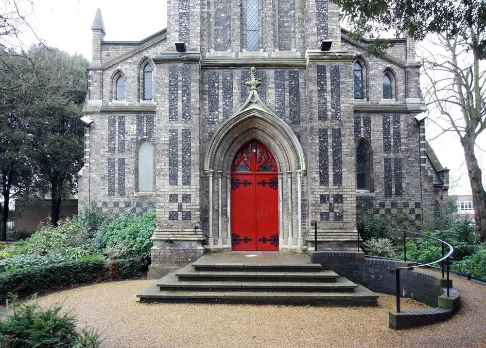 A historic church with a red door and Gothic architecture.