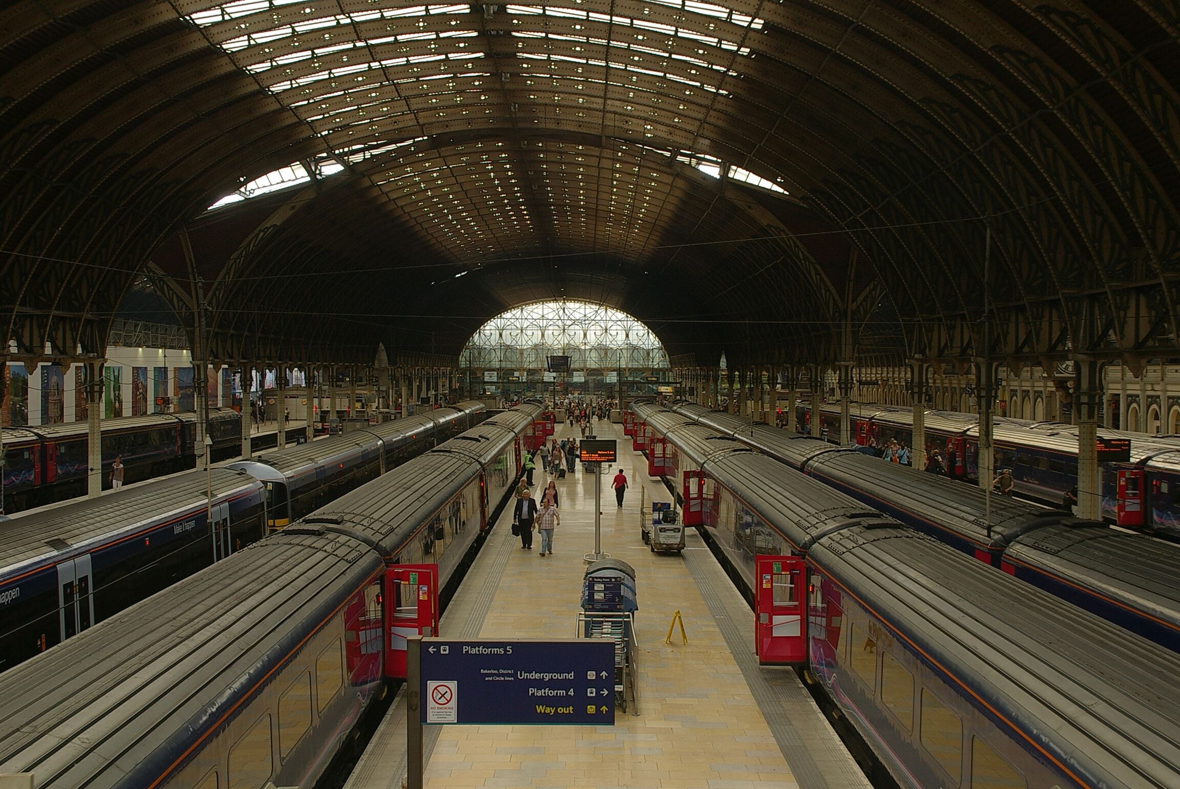 A spacious train station with multiple platforms and trains.