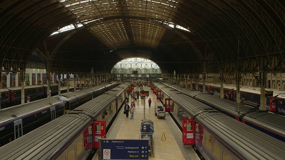 A spacious train station with multiple platforms and trains.