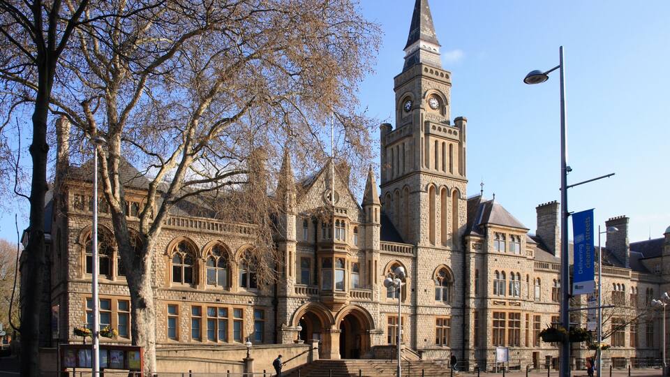 A historic stone building with a clock tower and arched windows.