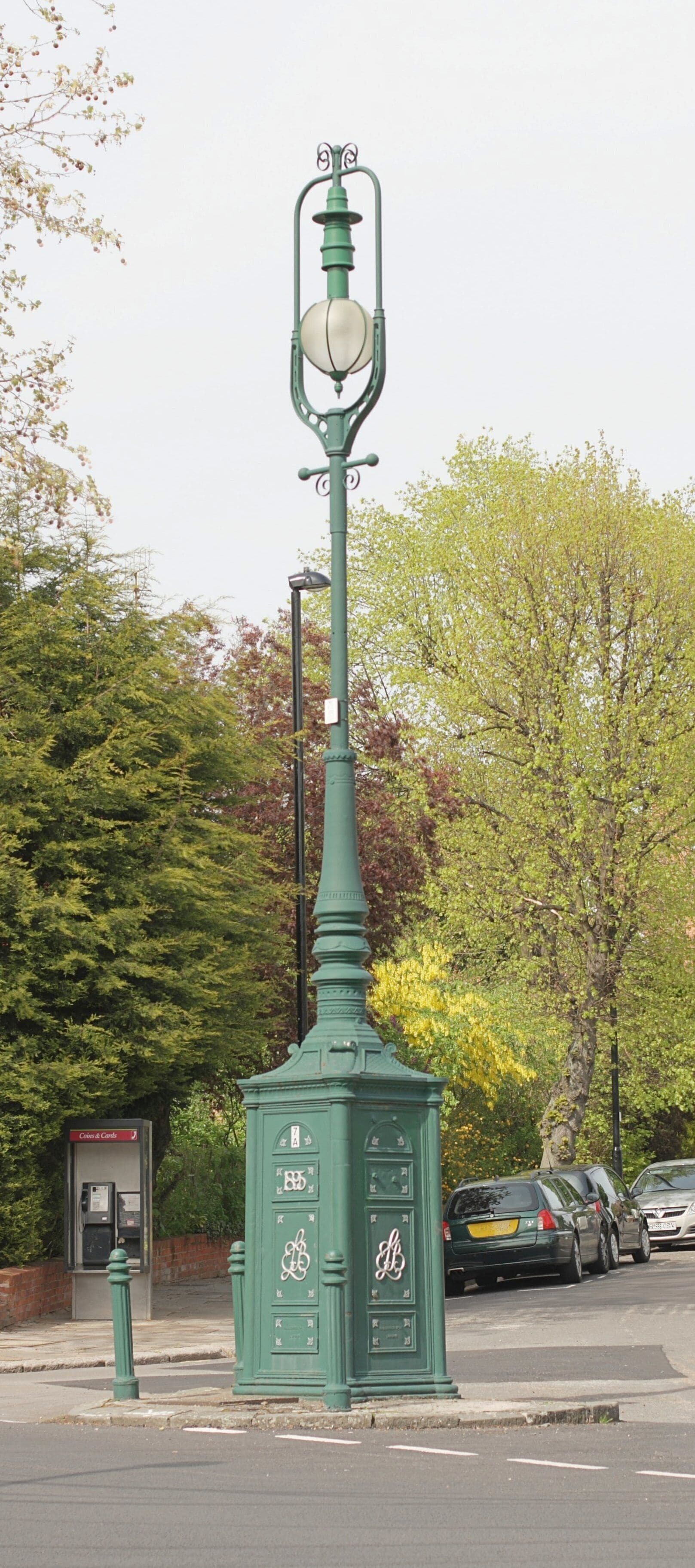 Original lamp standard dated 1905. Manufactured by Gallender Company Limited, London. This lamp post has been given protection by English Heritage and listed as Grade II. Situated at the junction of west end of Park Hill at the point it joins Mount Park Road, Ealing W5, UK It is part of Ealing's original electric street lighting system which started in 1894. In the background is an example of the current style of black-gloss lamp posts which started to be installed in 2007.