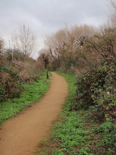 Wandle Trail The trail, followed by NCN22, has the river on its right as it approaches a turning leading to Weir Road on the left.