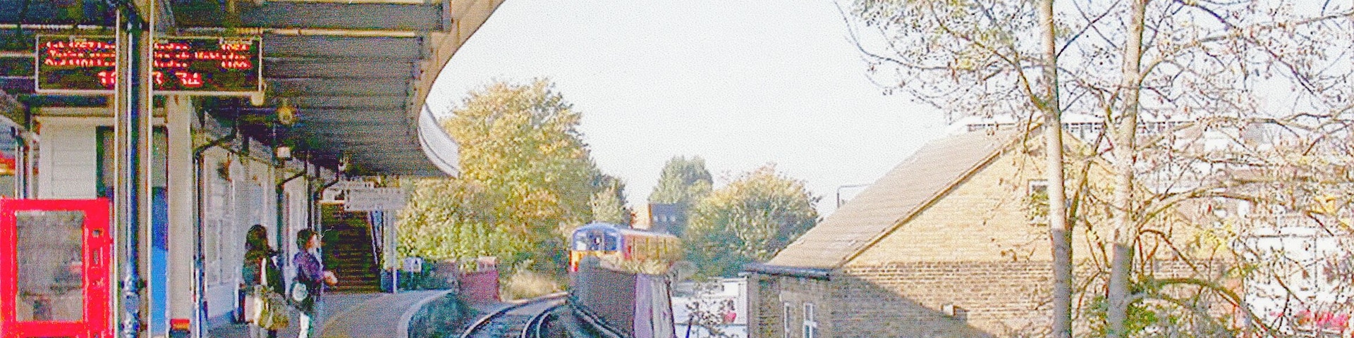 Raynes Park Station, Platform 1 2007. View westward, towards Motspur Park, Epsom etc., with Up local train for Waterloo arriving. The Up Epsom line, which comes from the south, burrows under the Down side and the main line to reach the Up platform.