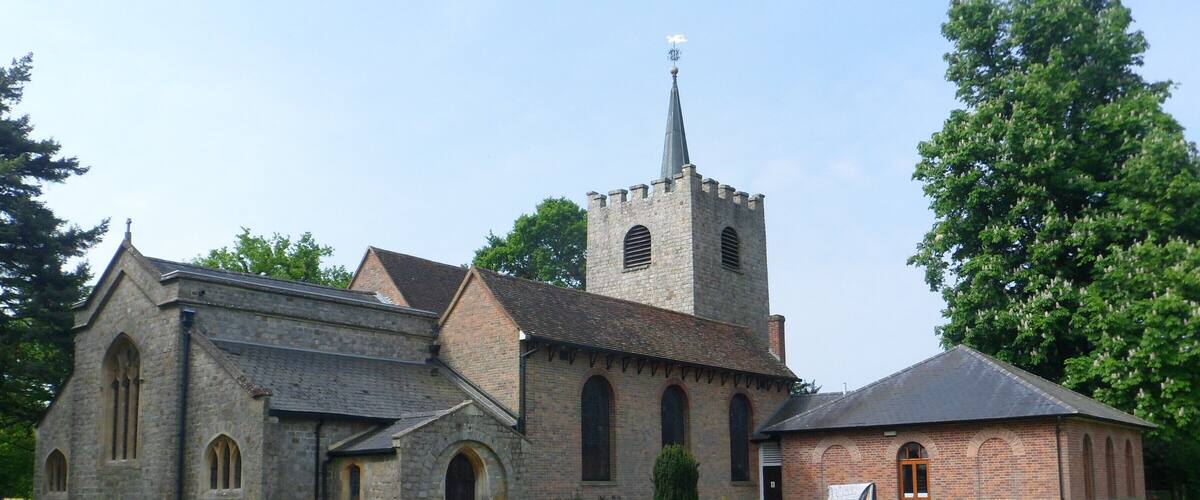 A church with a tower, surrounded by a cemetery with headstones.