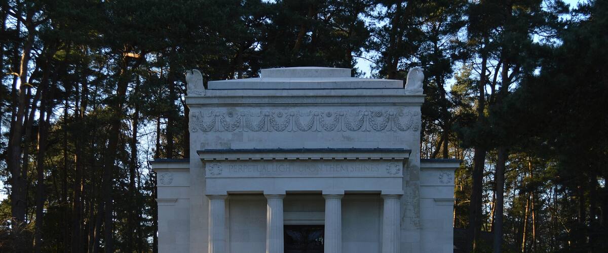 Um monumento neoclássico com colunas e uma inscrição.