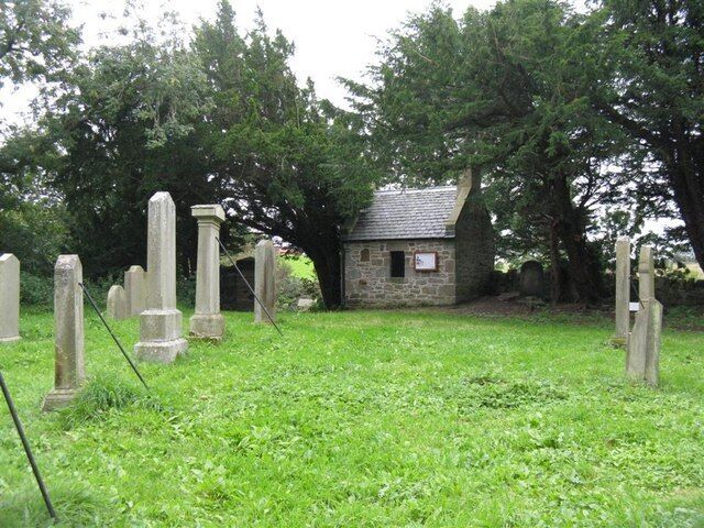 A cemetery with gravestones and a small stone building.
