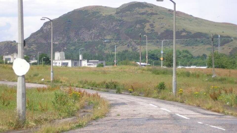 Eine ländliche Straße mit einem Berg im Hintergrund.