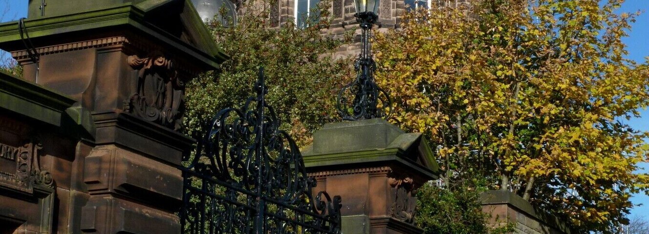 The gate and East Tower of the Royal Observatory, Edinburgh. This picture was taken soon after the refurbishment of the copper dome was completed, in October 2010. The colour of the new copper contrasts with the original 1894 copper.