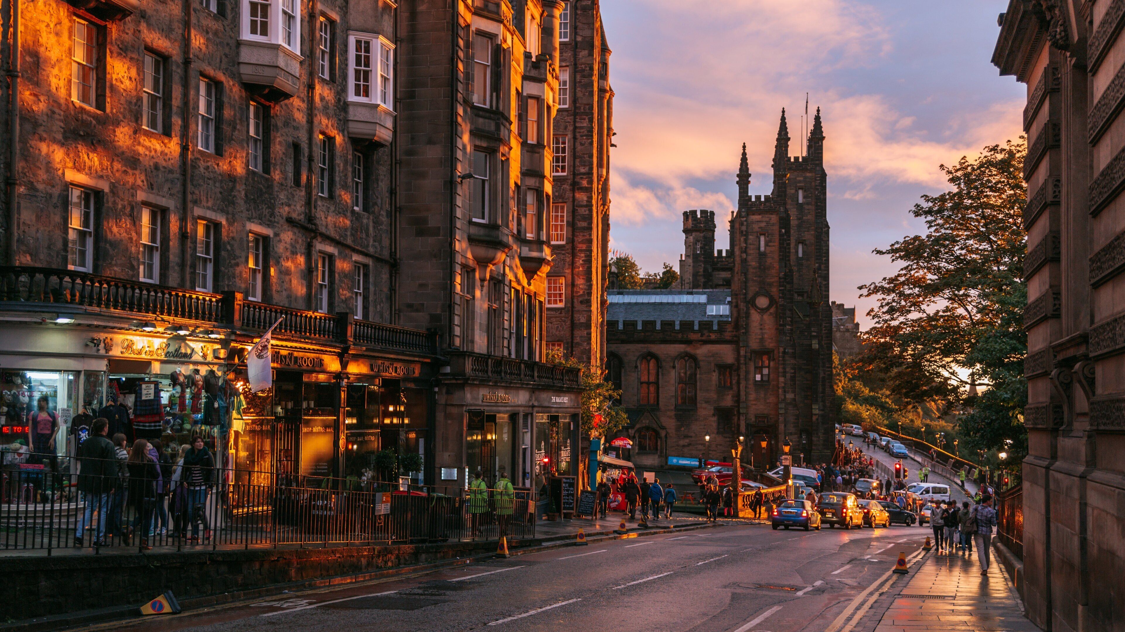 A city street with historic buildings, a prominent tower, and a pub named "Best in Scotland".