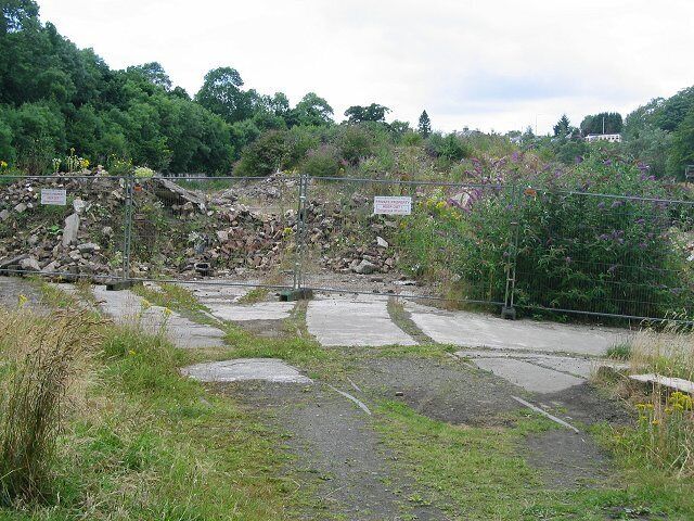 Kinleith Mill. The entrance to the former mill complex beside the Water of Leith is tucked into the northwest corner of this Pentland square. Photo taken from the walkway a former railway line. Note the rails going into the site. Derelict for years it is planned to develop the site for housing.