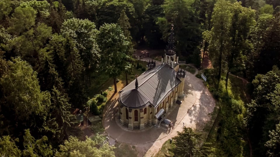 Vue aérienne d’une église entourée d’une forêt dense.