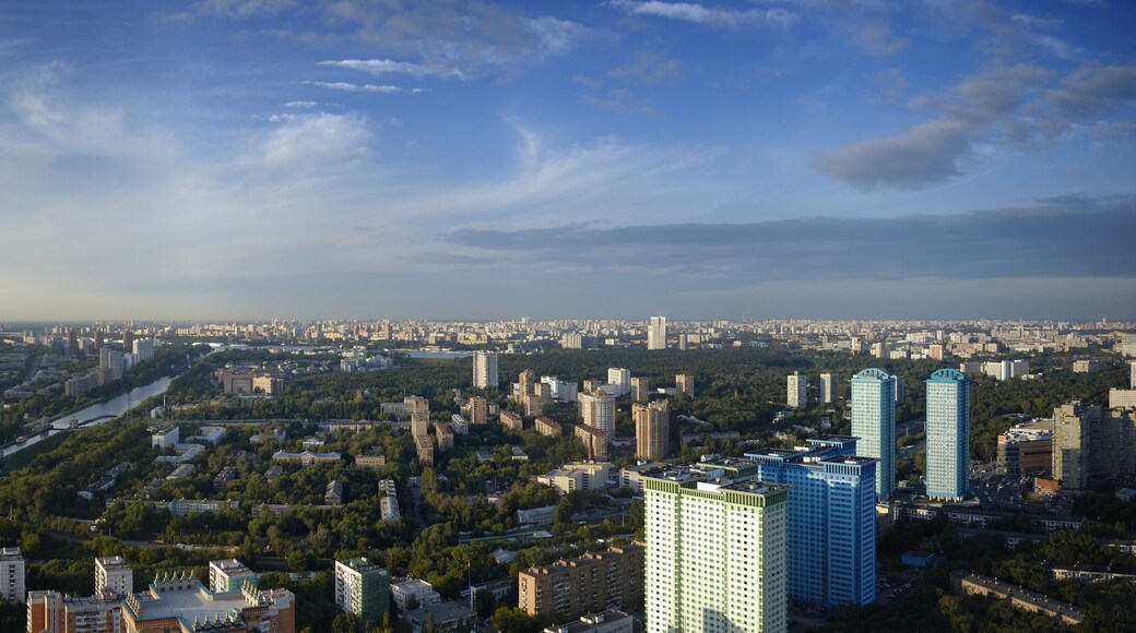 A cityscape with a river, green spaces, and modern buildings.