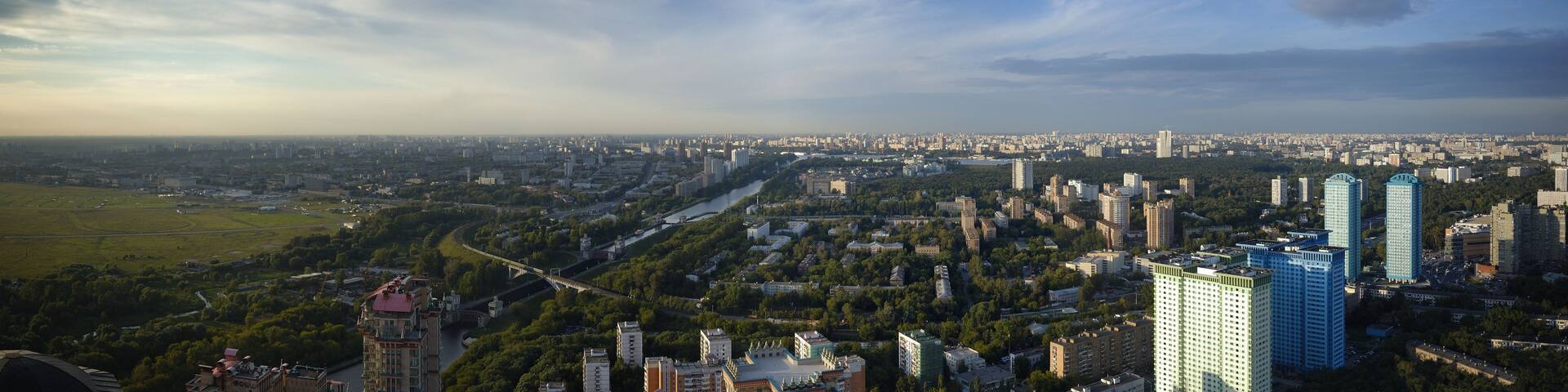 A cityscape with a river, green spaces, and modern buildings.