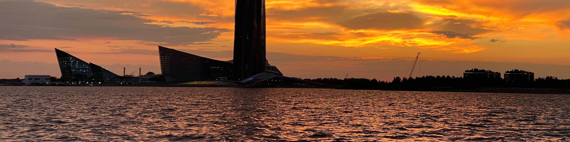 View from the yacht of the Gulf of Finland and the Lakhta Center skyscraper on the background of a pink sunset, the coastline,the tallest building in Europe.Russia,Saint Petersburg,14.04.2022