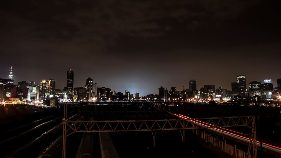 Night time view of commuter trains under Nelson Mandela Bridge in Braamfontein Johannesburg CBD