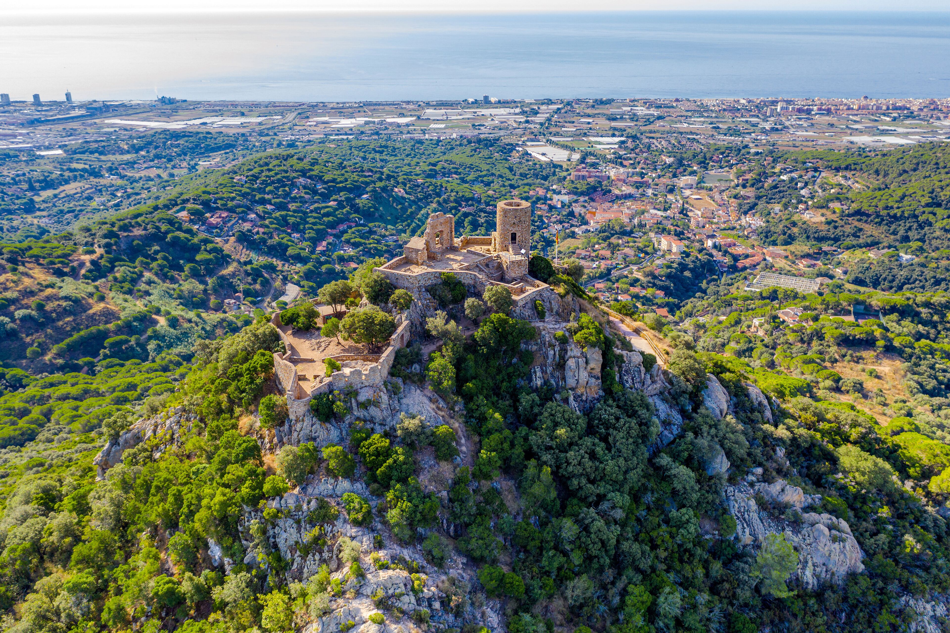 A historic fortress on a hill overlooking a coastal city.