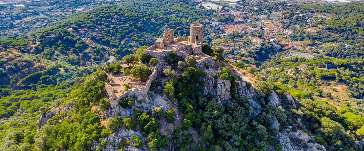 A historic fortress on a hill overlooking a coastal city.