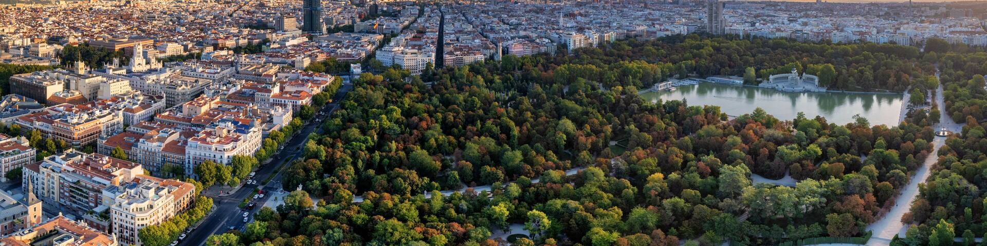 Aerial panoramic view of Parque El Retiro in Madrid, Spain at a golden hour sunrise