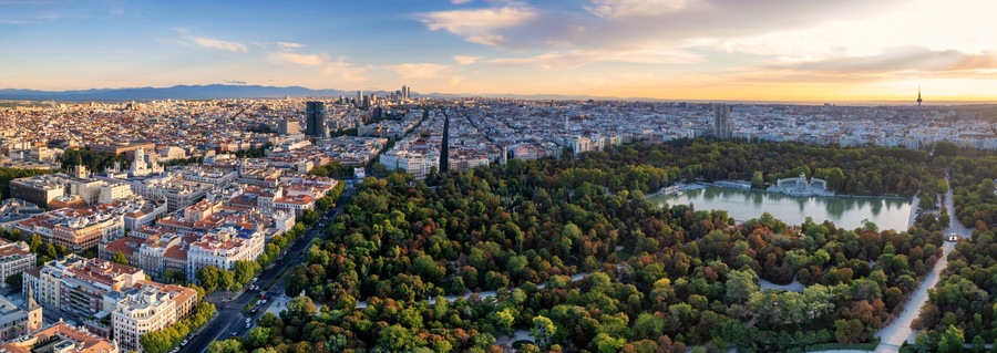 Aerial panoramic view of Parque El Retiro in Madrid, Spain at a golden hour sunrise