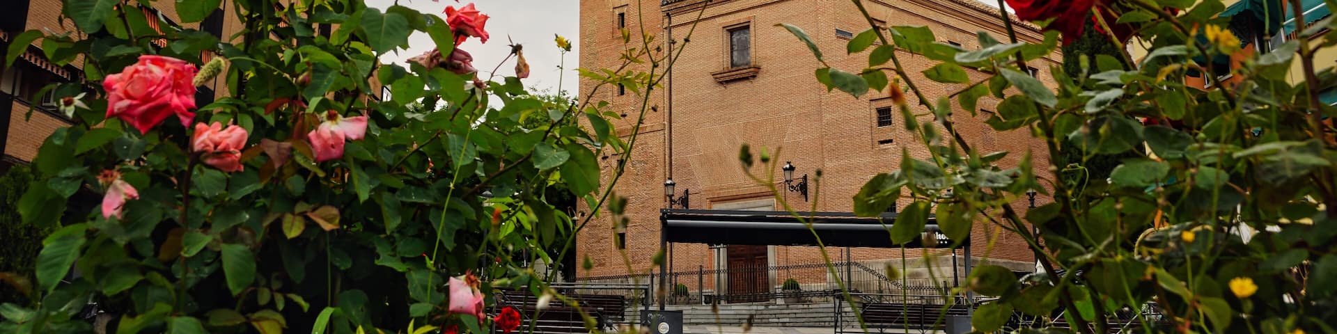 Bell tower of San Salvador Church in Leganes, Madrid, with red roses in the foreground.