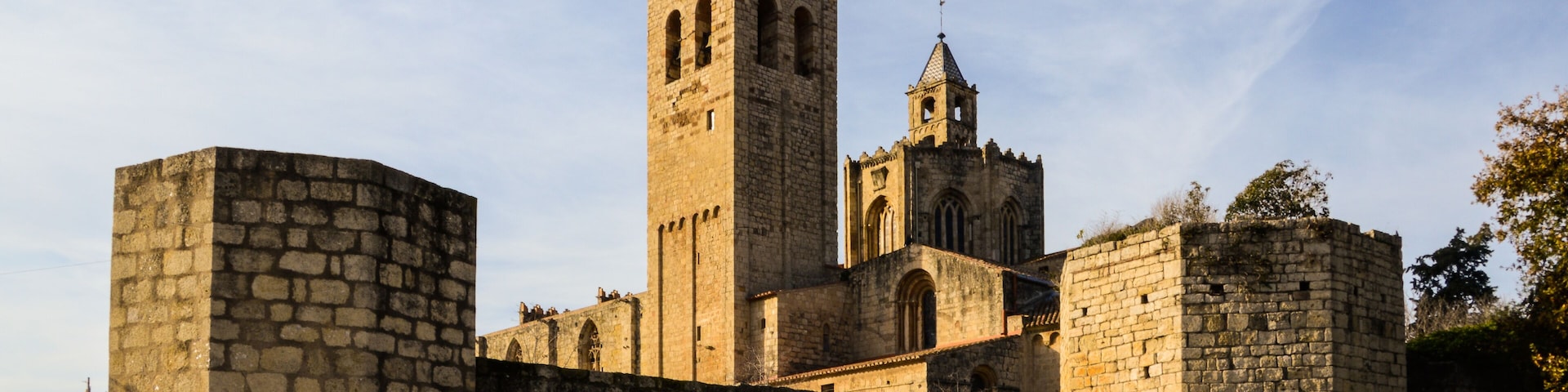 Una fortaleza de piedra histórica con una torre destacada y un edificio más pequeño contiguo.