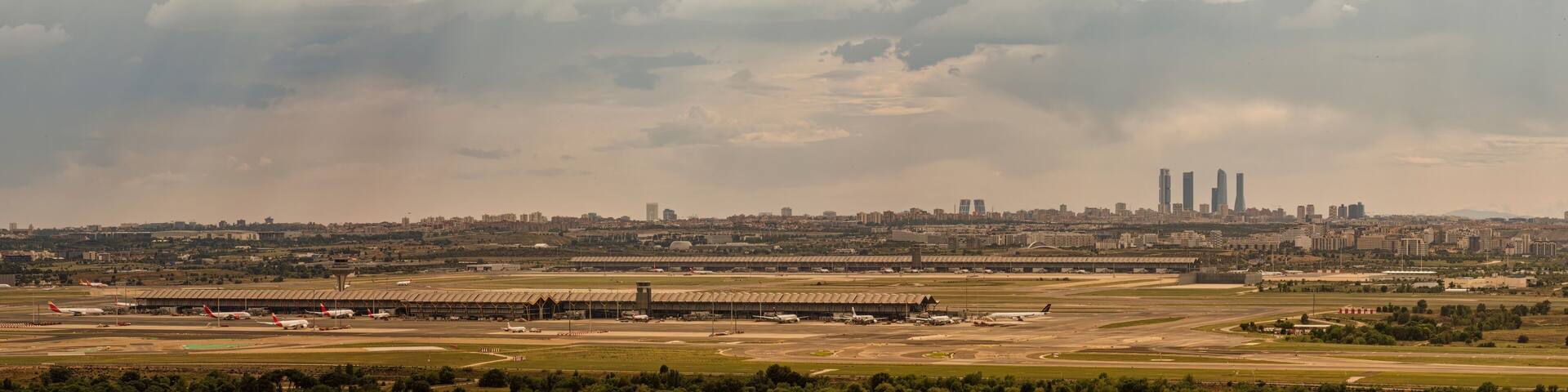 Panoramic photograph of the Skyline of the city of Madrid and the Madrid Barajas airport seen from the west with the first rays of sun after a summer storm