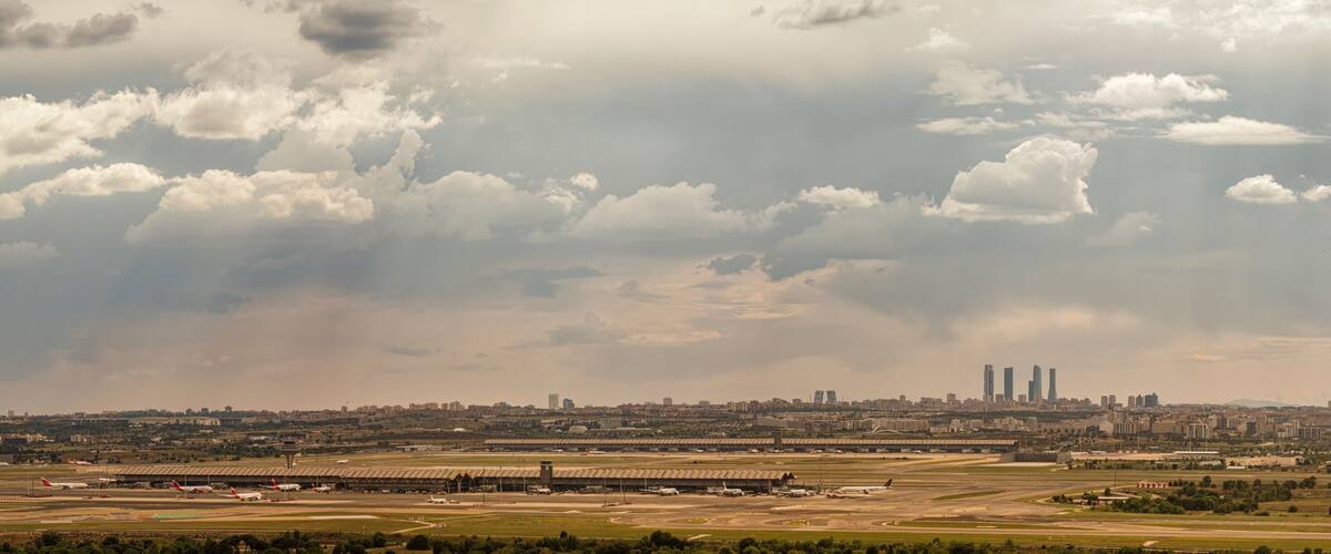 A cityscape with a large airport and a cloudy sky.