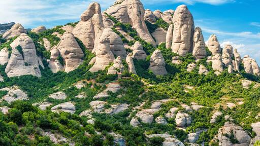 Een bergachtig landschap met opvallende rotsformaties en weelderige groene begroeiing.