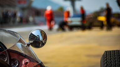 Una motocicleta antigua con un espejo retrovisor transparente y un logotipo visible en el frente.