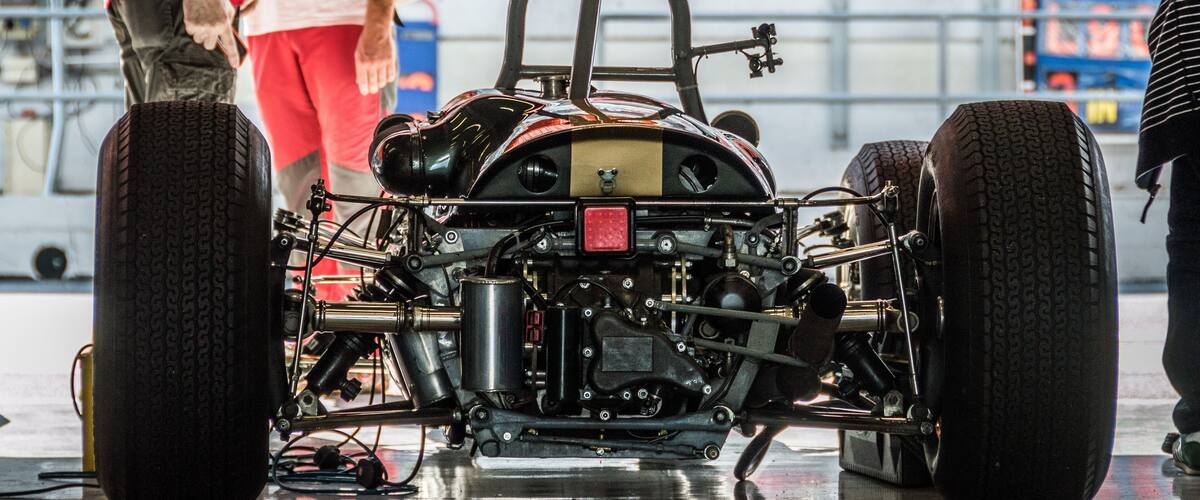 A custom-built race car with exposed engine and large tires.