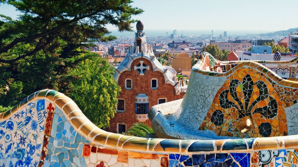 A colorful mosaic structure with a view of a cityscape in the background.
