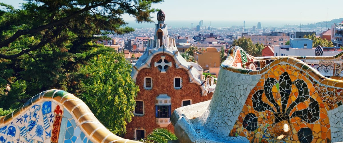 A colorful mosaic structure with a view of a cityscape in the background.