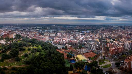Aerial panorama view of Castelldefels, popular Costa Brava Spanish beach town with modern buildings and hilltop medieval castle near Barcelona