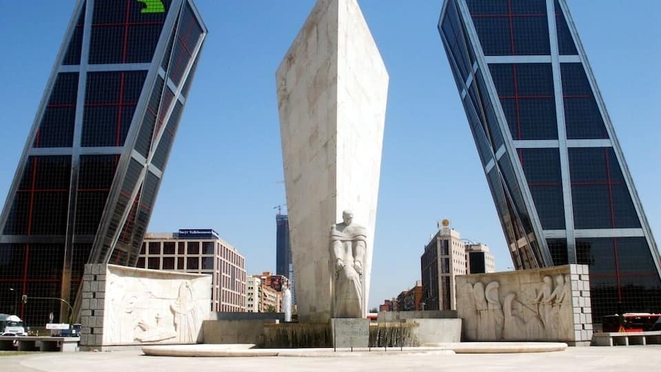 A modern plaza with a central monument and two tall buildings with 'REFAELIA' signage.