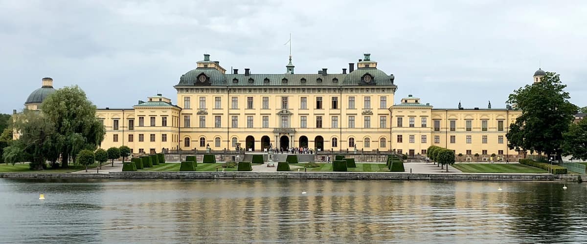 A large, historic building with a symmetrical facade, arched windows, and a central entrance.