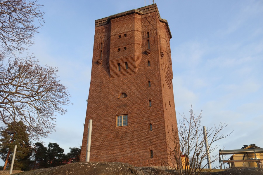 A tall brick tower with arched windows and a flat roof.