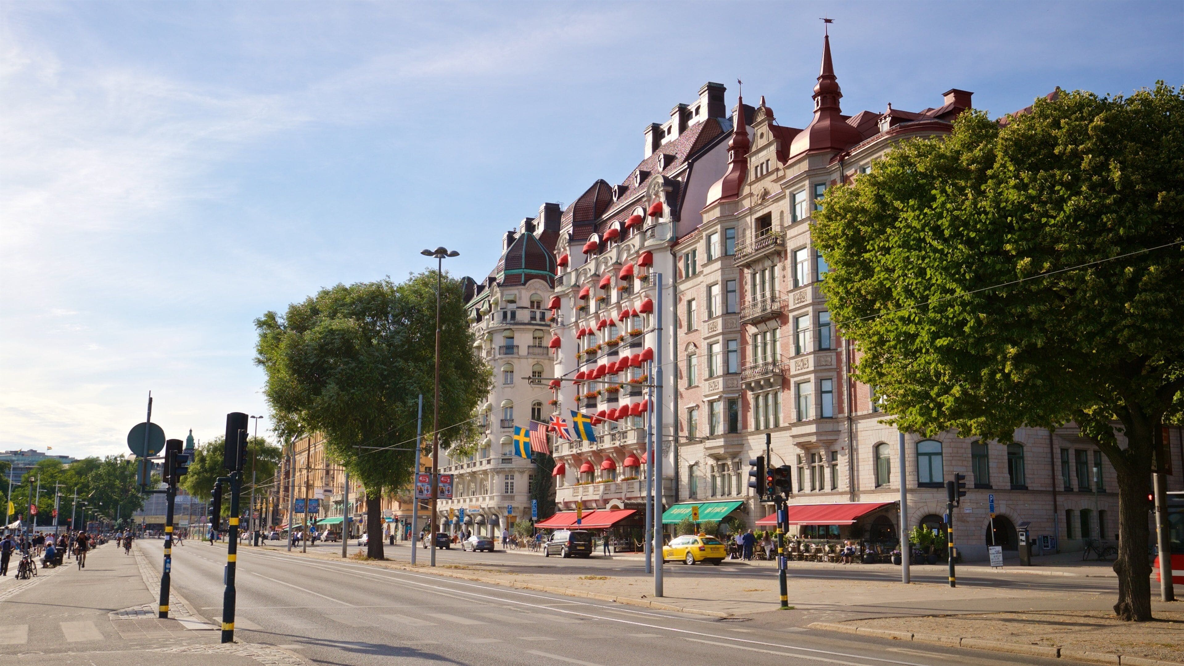 A street with historic buildings, flags, and a yellow taxi.