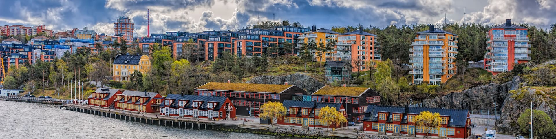 A coastal town with colorful buildings, a pier, and a rocky shoreline.