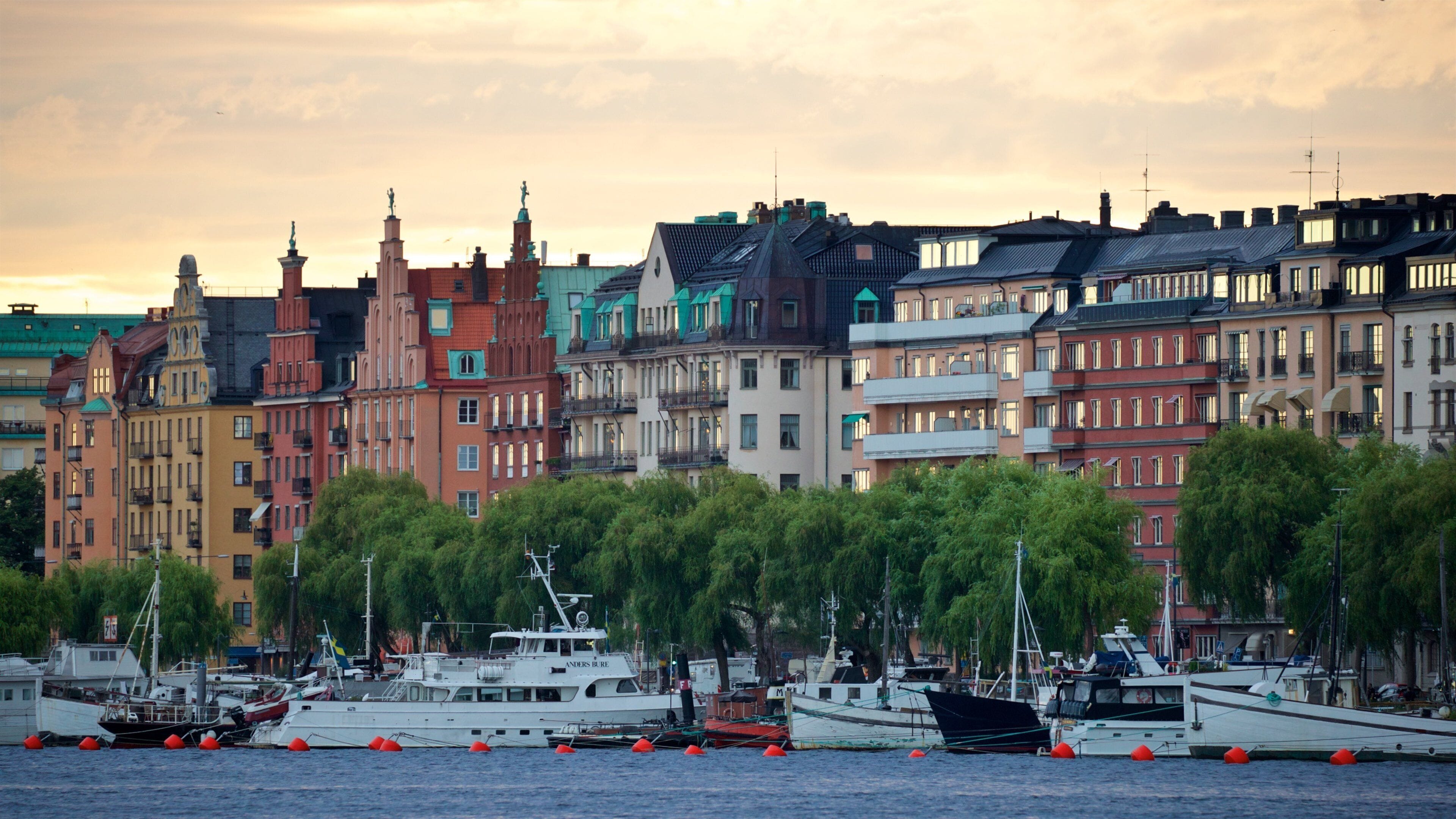 A waterfront with colorful buildings and boats docked at the harbor.