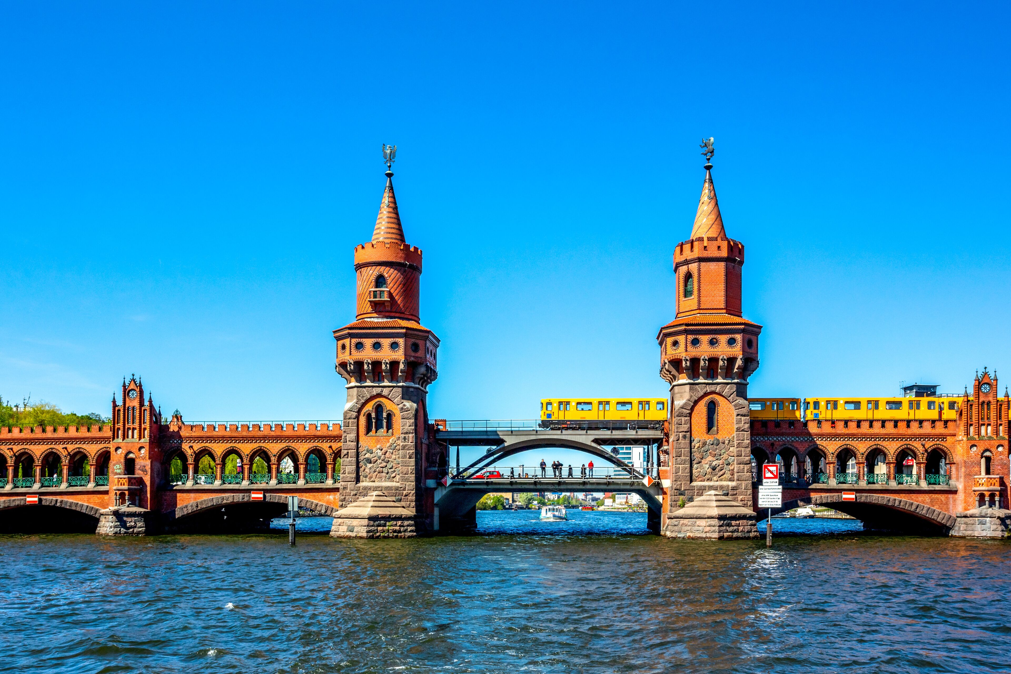 A historic bridge with two towers and a yellow tram.