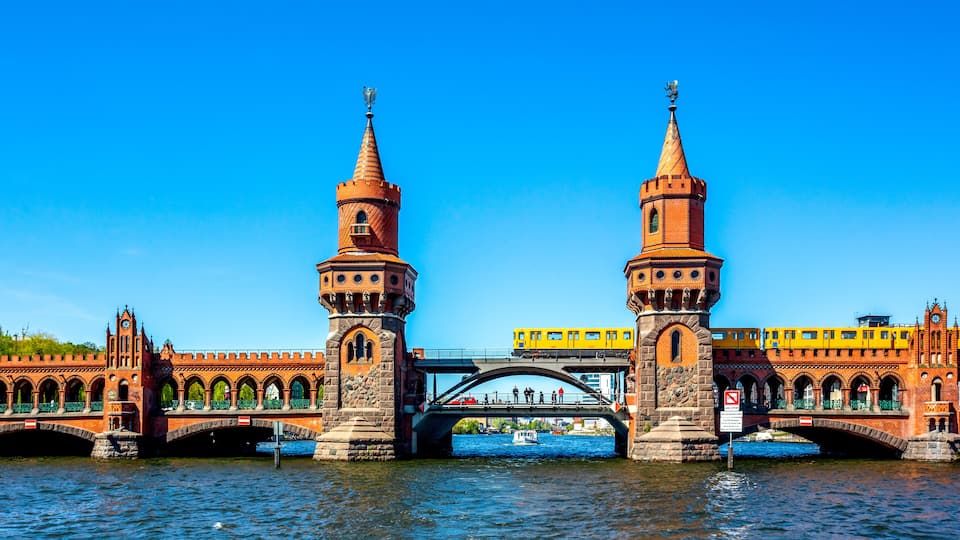 A historic bridge with two towers and a yellow tram.