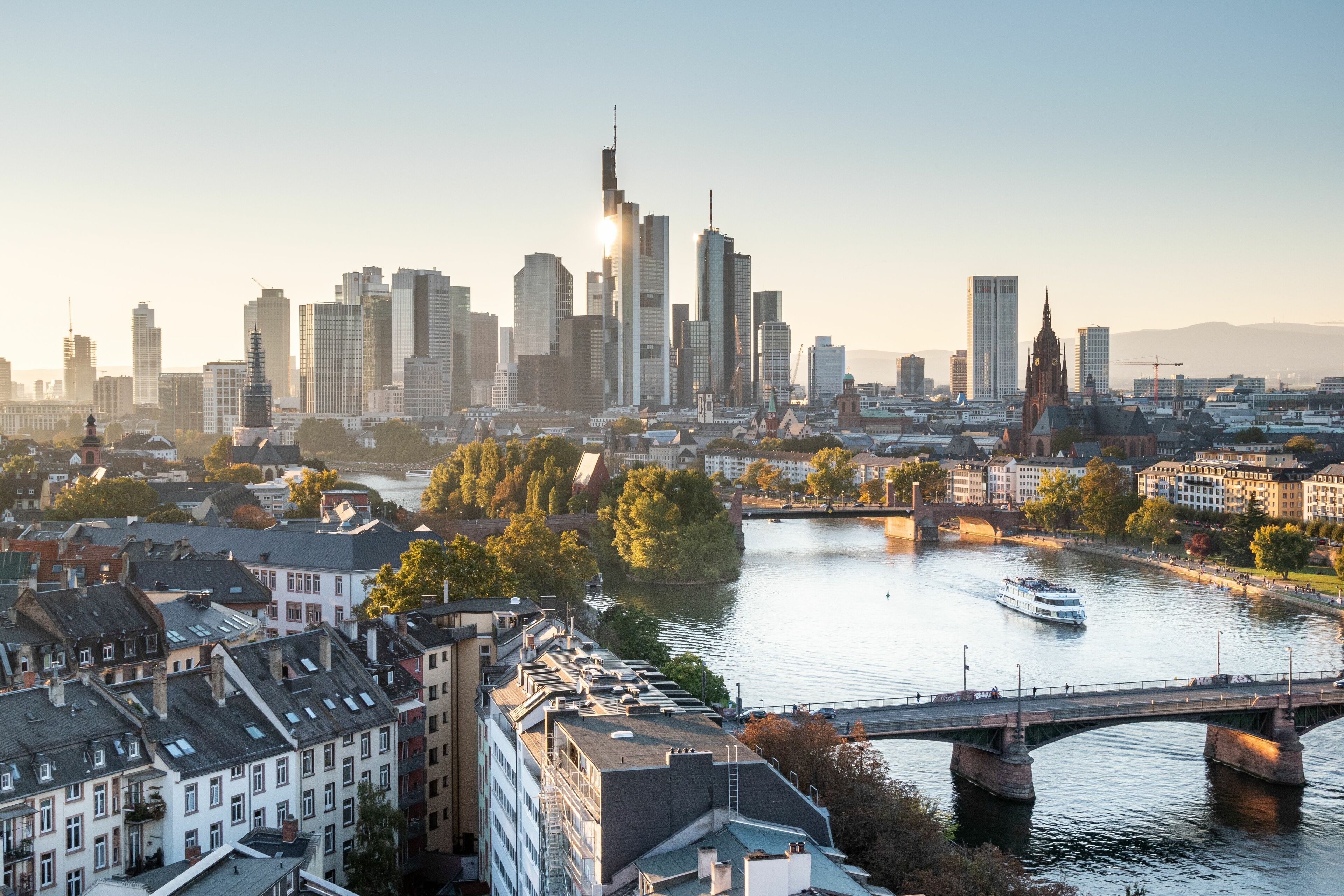 A cityscape with a river, a bridge, and a tall building.