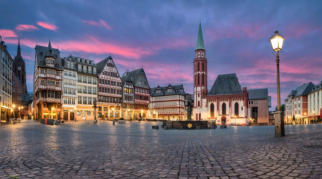 A cobblestone square with historic half-timbered buildings and a prominent church tower.