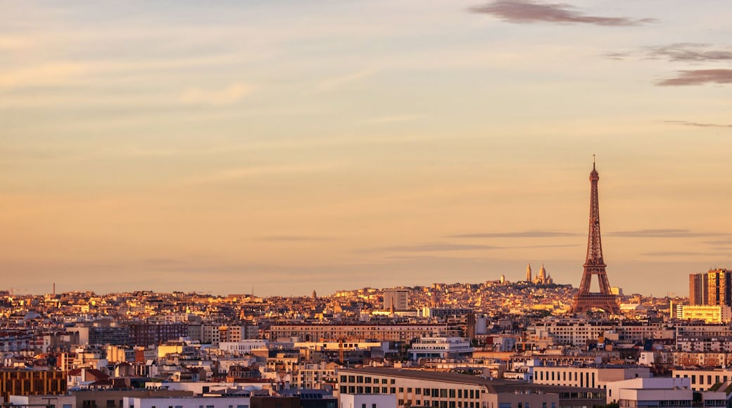 A cityscape with the Eiffel Tower and modern buildings at sunset.