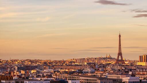 Une vue sur la ville, avec la Tour Eiffel et des bâtiments modernes, au coucher du soleil.