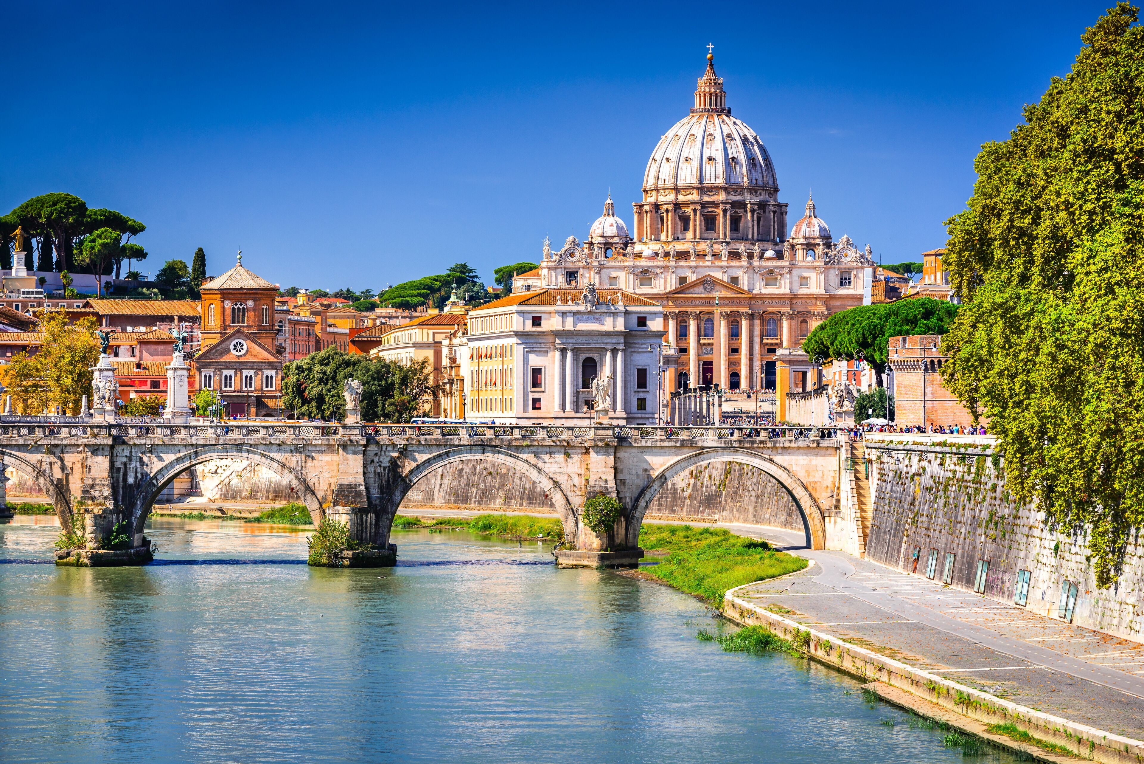 Rome, Italy. Vatican dome of Saint Peter Basilica (Italian: San Pietro) and Sant'Angelo Bridge, over Tiber river.