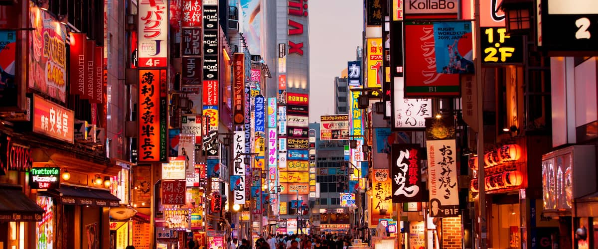 A busy urban street with numerous illuminated signs and billboards.