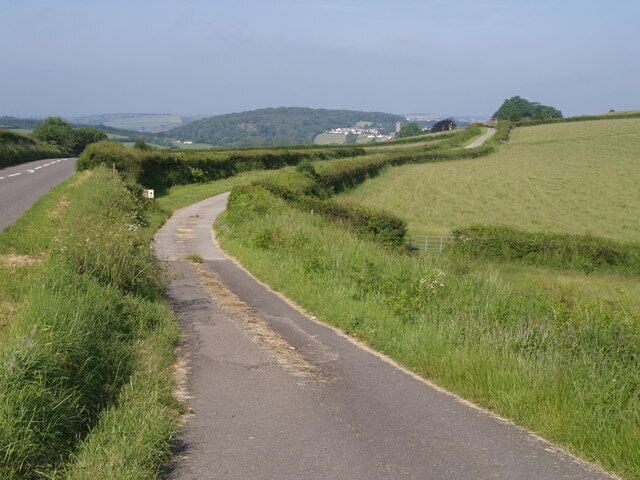 Routes to Lifton On the left is the former A30; on the right, Stowford Bridleway 11 climbs towards Castle Farm. Lifton Wood and the church tower are about 2 kilometres away.